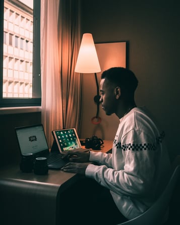 Image of person working on laptop beside an ipad